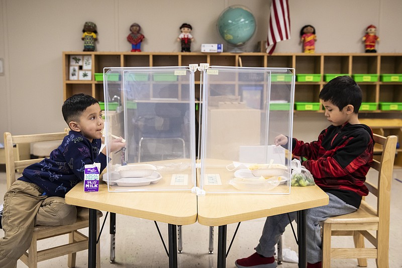 Preschool students eat lunch at Dawes Elementary in Chicago, Monday, Jan. 11, 2021. Chicago Public Schools students began their return to the classroom Monday as school doors opened to thousands of pre-kindergarten and some special education students after going remote last March due to the coronavirus pandemic. (Ashlee Rezin Garcia/Chicago Sun-Times via AP, Pool)