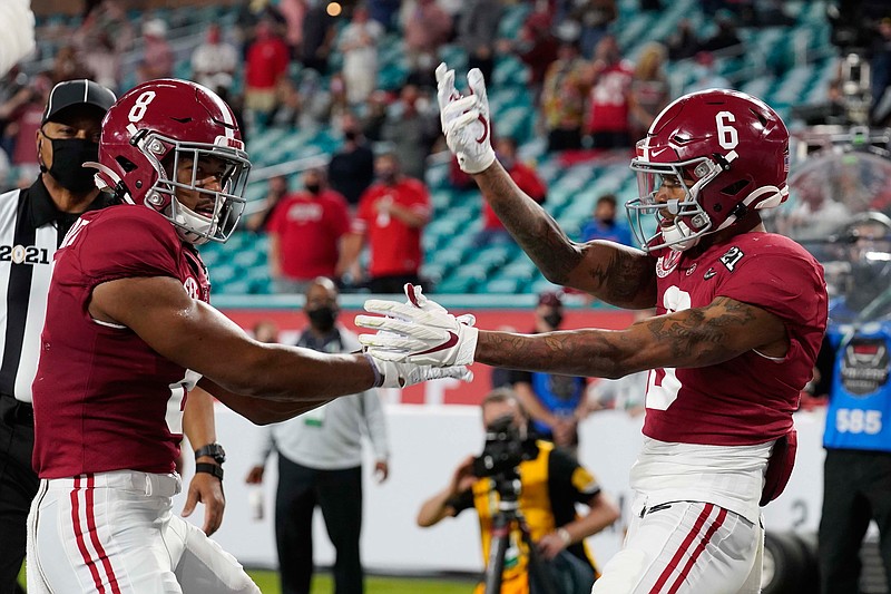 Alabama wide receiver John Metchie III, left, congratulates wide receiver DeVonta Smith, after Smith scored a touchdown against Ohio State during the first half of an NCAA College Football Playoff national championship game, Monday, Jan. 11, 2021, in Miami Gardens, Fla. (AP Photo/Chris O'Meara)