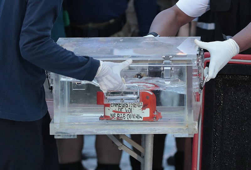 Members of the National Transportation Safety Committee carry a box containing the flight data recorder from the Sriwijaya Air flight SJ-182 retrieved from the Java Sea where the passenger jet crashed at the Tanjung Priok Port, Tuesday, Jan. 12, 2021. Indonesian navy divers searching the ocean floor on Tuesday recovered the flight data recorder from a Sriwijaya Air jet that crashed into the Java Sea with 62 people on board, Saturday, Jan. 9, 2021. (AP Photo/Dita Alangkara)