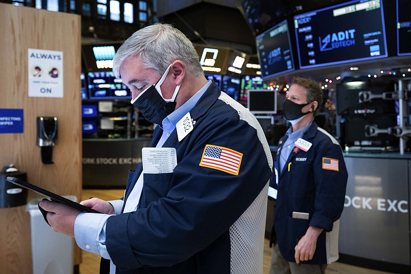 In this photo provided by the New York Stock Exchange, traders Edward MacCarthy, left, and Robert Charmak work on the trading floor, Tuesday, Jan. 12, 2021. U.S. stocks are drifting near their record heights Tuesday, while Treasury yields keep marching higher amid expectations that the economy will pull out of its slump after a powerful recovery sweeps the globe later this year. (Colin Ziemer/New York Stock Exchange via AP)
