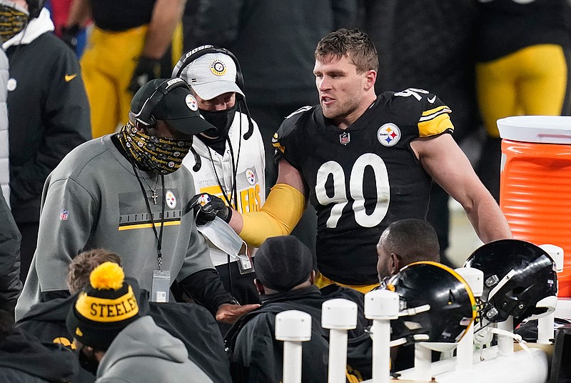 Pittsburgh Steelers head coach Mike Tomlin, left, talks with his defense, including outside linebacker T.J. Watt (90), during the second half of an NFL wild-card playoff football game against the Cleveland Browns, Sunday, Jan. 10, 2021, in Pittsburgh. (AP Photo/Keith Srakocic)