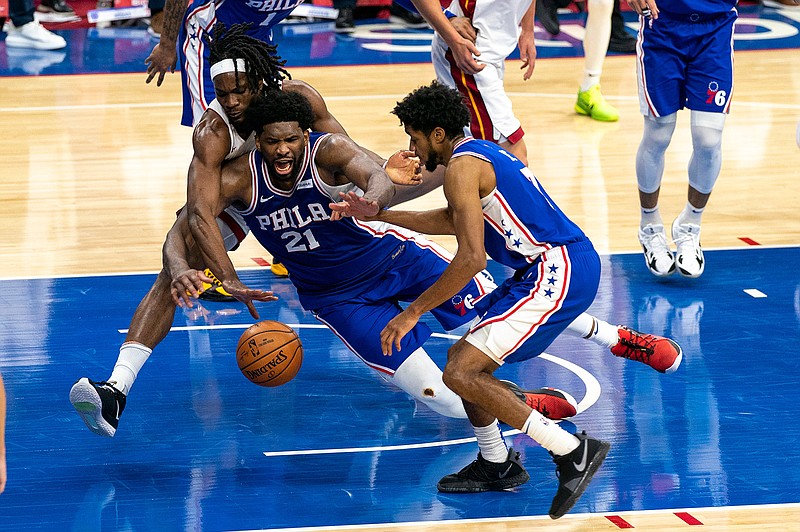 Philadelphia 76ers' Joel Embiid, center, battles with Miami Heat's Precious Achiuwa, left, for a loose ball as 76ers' Isaiah Joe, right, tries to help during overtime of an NBA basketball game Tuesday, Jan. 12, 2021, in Philadelphia. (AP Photo/Chris Szagola)