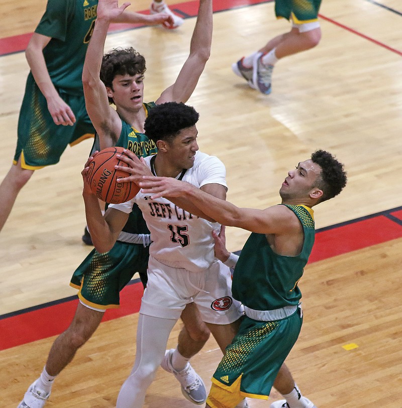 Sterling DeSha of the Jays searches for a teammate to pass to as Rock Bridge teammates Nick Arndt (left) and Xavier Sykes defend on the play Tuesday at Fleming Fieldhouse.