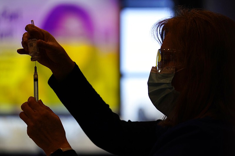 In this Dec. 29, 2020, file photo, Penny Cracas, with the Chester County, Pa., Health Department, fills a syringe with the Moderna COVID-19 vaccine before administering it to emergency medical workers and healthcare personnel at the Chester County Government Services Center in West Chester, Pa. The Trump administration on Tuesday, Jan. 12, 2021, announced plans to further speed up delivery of the shots by releasing second doses of the Pfizer-BioNTech and Moderna vaccines, practically doubling supply. (AP Photo/Matt Slocum, File)