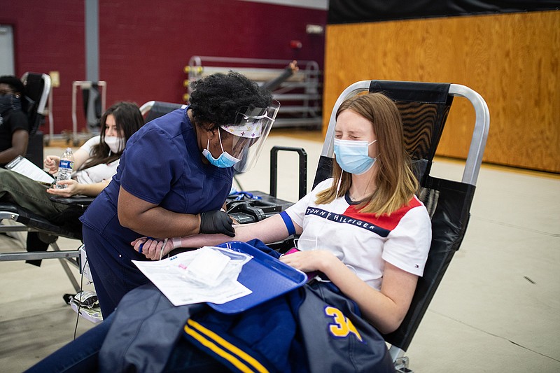 Liberty-Eylau High School junior Madison Smith winces Tuesday as Tanesha Gulley, team leader at Lifeshare Blood Centers, sticks her with a needle. Madison donated blood in the Rader Dome at L-EHS.
