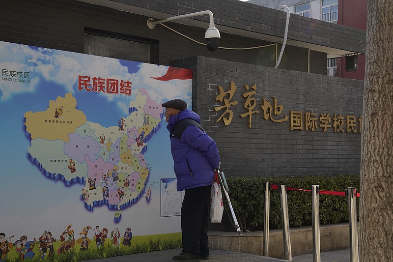 An elderly Chinese man looks at map of Chinese showing its different ethnic groups and the slogan "Ethnic Unity" in Beijing, China Monday, Jan. 11, 2021. A Chinese official on Monday denied Beijing has imposed coercive birth control measures among Muslim minority women, following an outcry over a tweet by the Chinese Embassy in Washington claiming that government polices had freed women of the Uighur ethnic group from being "baby-making machines." (AP Photo/Ng Han Guan)