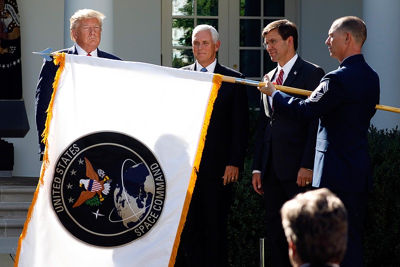 In this Aug. 29, 2019 file photo, President Donald Trump watches with Vice President Mike Pence and Defense Secretary Mark Esper as the flag for U.S. space Command is unfurled as Trump announces the establishment of the U.S. Space Command in the Rose Garden of the White House in Washington.   The U.S. Air Force is expected to announce Huntsville, Ala. as the location for the U.S. Space Command headquarters, according to  Gov. Kay Ivey.   The governor said she was informed of the decision Wednesday, Jan. 13, 2021.   (AP Photo/Carolyn Kaster, File)