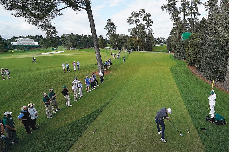 In this Nov. 15, 2020, file photo, Dustin Johnson tees off in front of a few fans on the 18th hole during the final round of the Masters in Augusta, Ga.