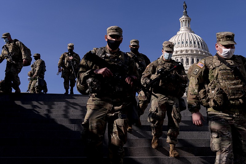 Members of the National Guard walk past the Dome of the Capitol Building on Capitol Hill in Washington, Thursday, Jan. 14, 2021. (AP Photo/Andrew Harnik)