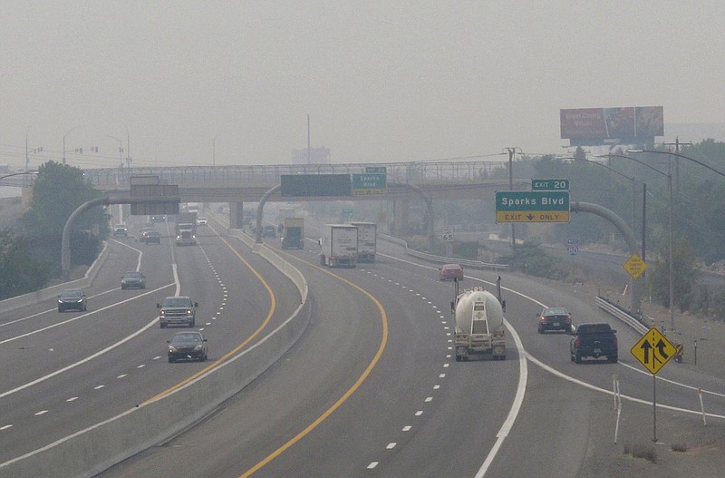 In this Wednesday, Aug. 19, 2020. file photo, smoke from California wildfires up to 200 miles away obscures the view of traffic traveling on Interstate 80, looking west in Sparks, Nev. Local schools canceled all outdoor activities as the air quality index approached the "very unhealthy" category for the general population Wednesday afternoon. (AP Photo/Scott Sonner)