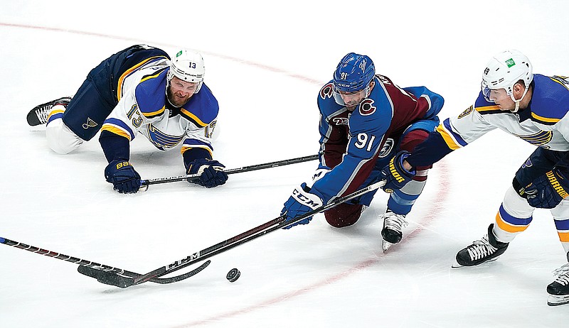 Avalanche center Nazem Kadri (center) fights for control of the puck with Blues left wing Kyle Clifford (left) and center Ivan Barbashev in the first period of Friday night's game in Denver.