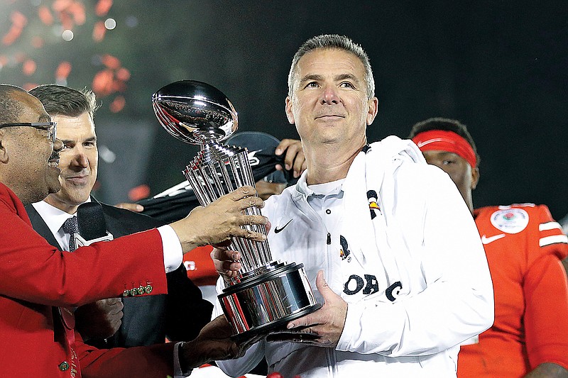 In this Jan. 1, 2019, file photo, Ohio State coach Urban Meyer holds the trophy after the team's 28-23 win against Washington in the Rose Bowl in Pasadena, Calif.