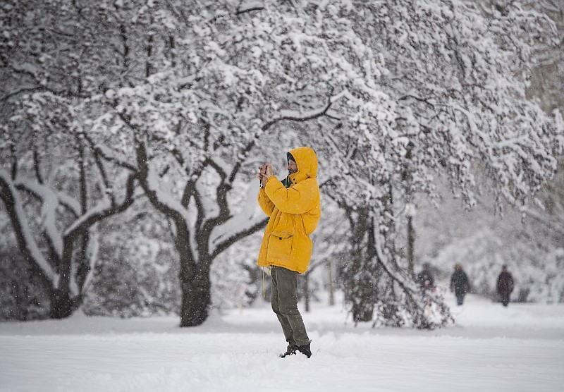 A person takes a photo with their phone during a major snowstorm in Ottawa on Saturday, Jan. 16, 2021.   (Justin Tang/The Canadian Press via AP)