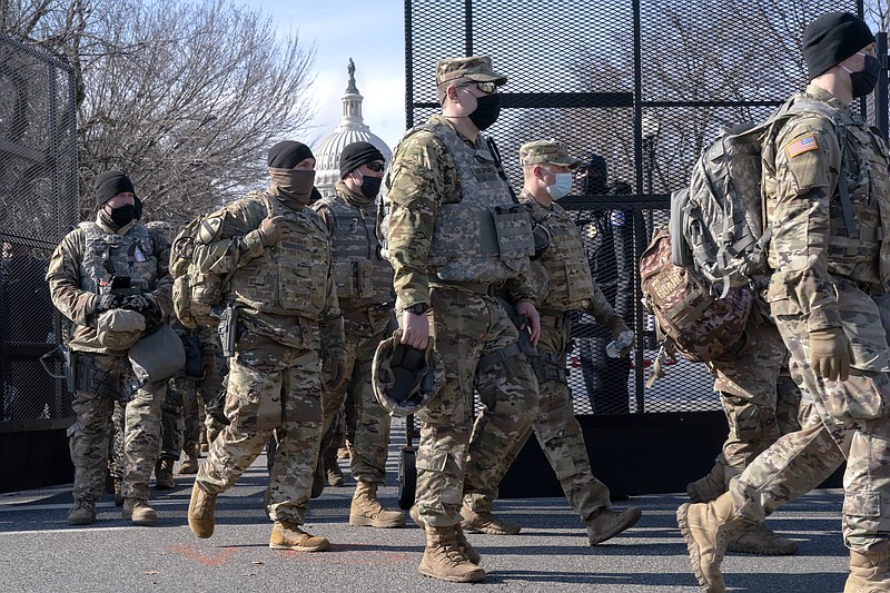 With the U.S. Capitol in the background, members of the National Guard change shifts as they exit through anti-scaling security fencing on Saturday, Jan. 16, 2021, in Washington as security is increased ahead of the inauguration of President-elect Joe Biden and Vice President-elect Kamala Harris. (AP Photo/Jacquelyn Martin)