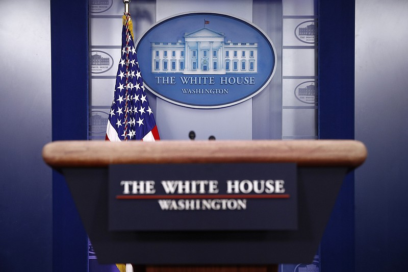 FILE - In this March 22, 2020, file photo a plaque depicting the White House is posted behind a podium in the James Brady Press Briefing Room of the White House in Washington. When Joe Biden takes the oath of office Wednesday, Jan. 20, 2021, he will begin to reshape the office of the presidency itself as he sets out to lead a bitterly divided nation grappling with a devastating pandemic and an insurrection meant to stop his ascension to power. (AP Photo/Patrick Semansky, File)