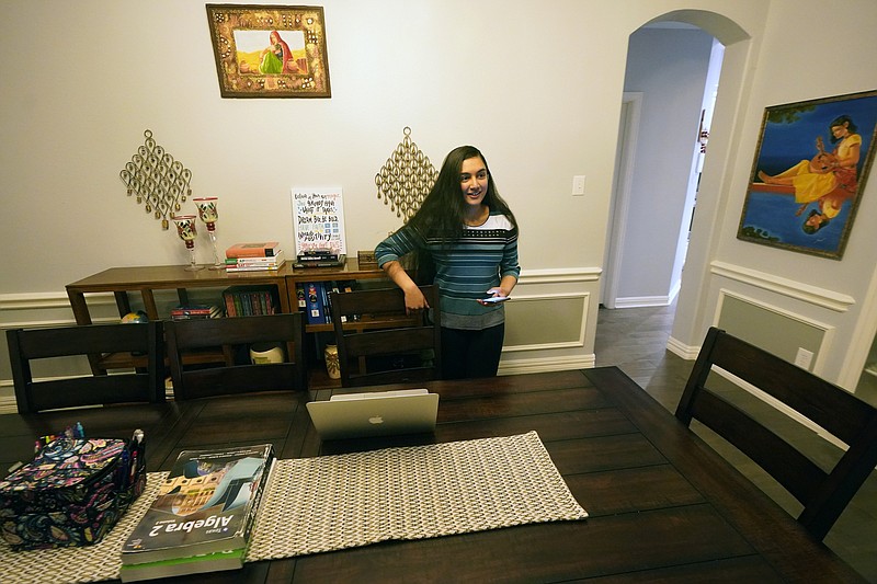 Charvi Goyal, 17, prepares to jump online for a tutoring session she gives to a junior high student from her family's home Monday, Jan. 4, 2021, in Plano, Texas. Goyal is part of a group of high school students that put together their own volunteer online tutoring service to help k-12 during the pandemic. (AP Photo/LM Otero)