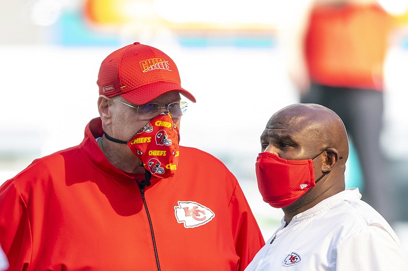 In this Dec. 13, 2020, file photo, Chiefs head coach Andy Reid and offensive coordinator Eric Bieniemy wear masks as they talk on the field before the Chiefs take on the Dolphins during a game in Miami Gardens, Fla.