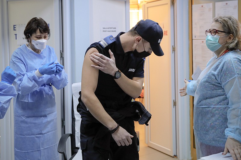 In this photo taken on Friday, Jan. 15, 2021 A Romanian gendarme leaves after getting a COVID-19 vaccine at a hospital in Bucharest, Romania. Across the Balkans and the rest of the nations in the southeastern corner of Europe, a vaccination campaign against the coronavirus is overshadowed by heated political debates or conspiracy theories that threaten to thwart the process. In countries like the Czech Republic, Serbia, Bosnia, Romania and Bulgaria, skeptics have ranged from former presidents to top athletes and doctors. Nations that once routinely went through mass inoculations under Communist leaders are deeply split over whether to take the vaccines at all.  (AP Photo/Vadim Ghirda)