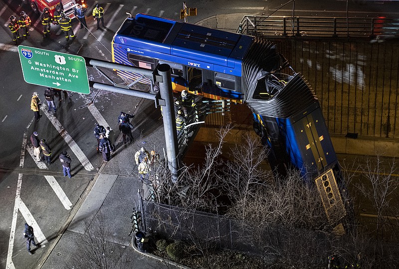 A bus in New York City which careened off a road in the Bronx neighborhood of New York is left dangling from an overpass Friday, Jan. 15, 2021, after a crash late Thursday that left the driver in serious condition, police said. (AP Photo/Craig Ruttle)