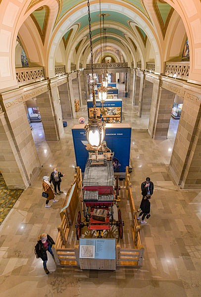 Visitors to Missouri's Capitol look over the stagecoach on display as they take time to tour the Missouri State Museum on Monday, Jan. 18, 2021. 