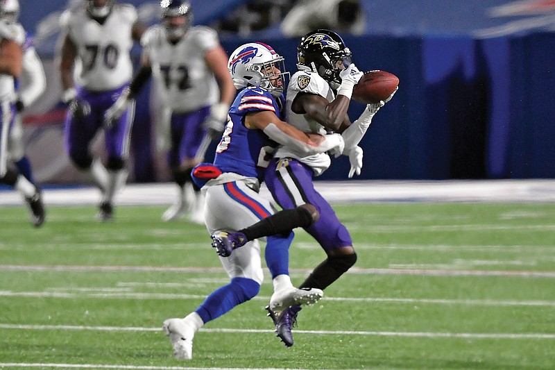 Ravens wide receiver Marquise Brown catches a pass in front of Bills safety Micah Hyde during last Saturday's divisional playoff game in Orchard Park, N.Y.