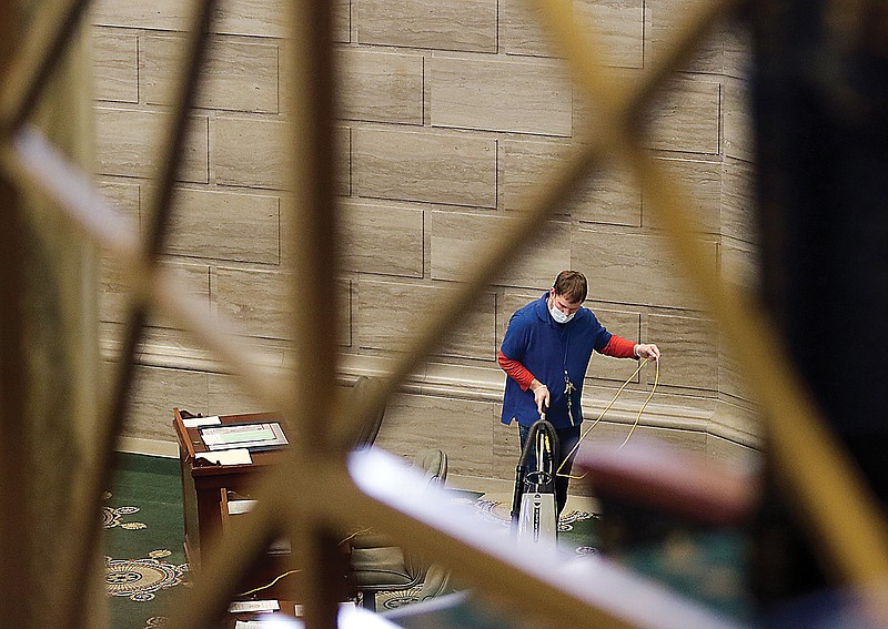 A worker vacuums the Missouri Senate floor on Thursday afternoon. A rapid COVID-19 testing site is scheduled to open in the basement of the building during the legislative session. 