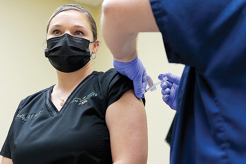 Jefferson City Medical Group nurse Holly Rowden receives a COVID-19 vaccine from LPN Greg Rehagen on Thursday after JCMG finished its vaccine appointments to the public for the day. The COVID-19 vaccine has no kinds of preservatives in it, so doses that are thawed for use must be used within six hours of their reconstitution.