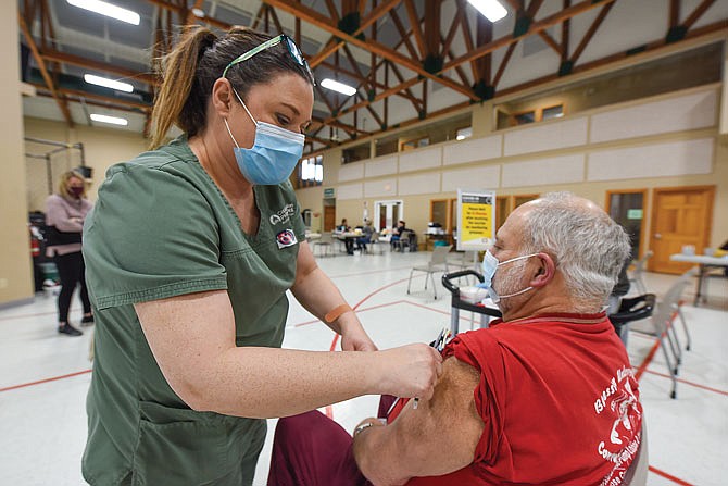 John Boessen receives a COVID-19 vaccine from Sally Phillips, LPN, as Capital Region Medical Center hosted a vaccination clinic Friday, Jan. 22, 2021, for registered patients at Capital West Christian Church Event Center. 