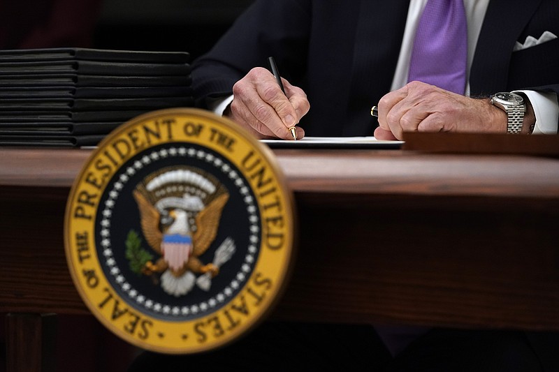 FILE - In this Jan. 21, 2021, file photo President Joe Biden signs executive orders after speaking about the coronavirus in the State Dinning Room of the White House in Washington. (AP Photo/Alex Brandon, File)