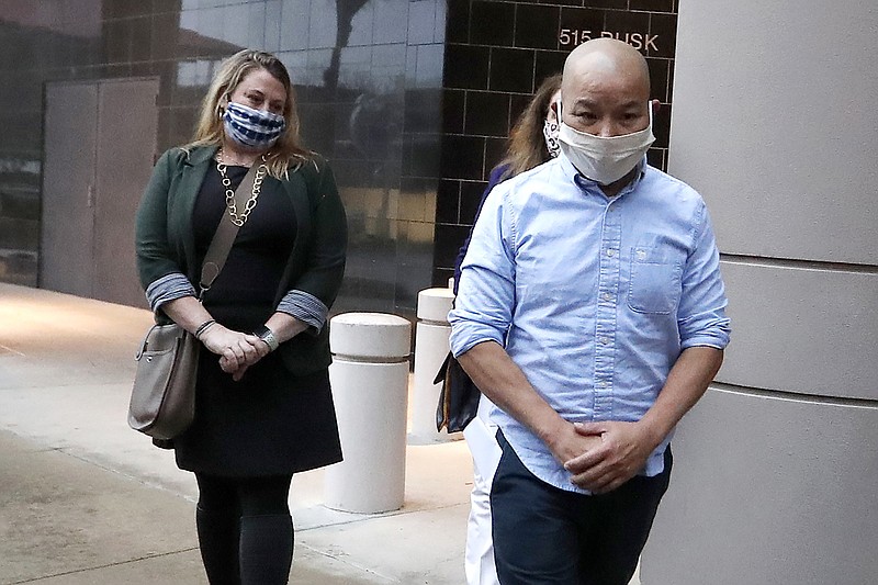 In this Jan. 21, 2021, photo former Houston Police Officer Tam Pham walks out of the Federal Courthouse downtown in Houston after he appeared in court following his arrest Wednesday on federal charges tied to Capitol violence. Police departments across the country are reviewing the behavior of dozens of officers who were in Washington on the day of a riot at the U.S. Capitol. (Karen Warren/Houston Chronicle via AP)