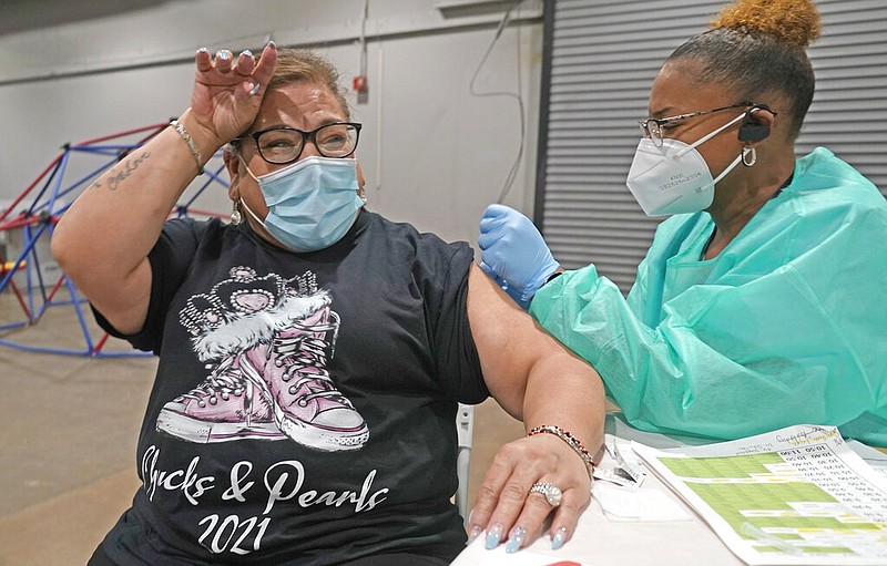 Francine Cano, left, reacts as she receives the COVID-19 vaccine from Lesia Turner at the Dallas County mass vaccination site at Fair Park Wednesday, Jan. 20, 2021, in Dallas.