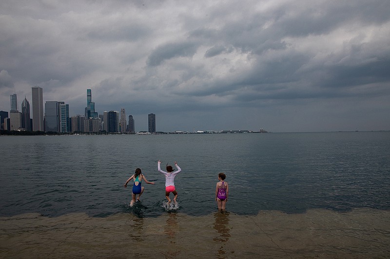 Kids take dip in Lake Michigan at Solidarity Drive as thunderstorm clouds approach Chicago on Aug. 10, 2020. (Zbigniew Bzdak/Chicago Tribune/TNS)