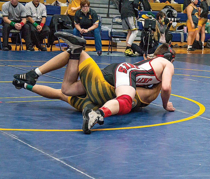 Clayton Hurley of Jefferson City works Jerico Caliston of Sedalia Smith-Cotton onto his back Saturday in their 160-pound match in the CMAC Tournament at Rackers Fieldhouse.