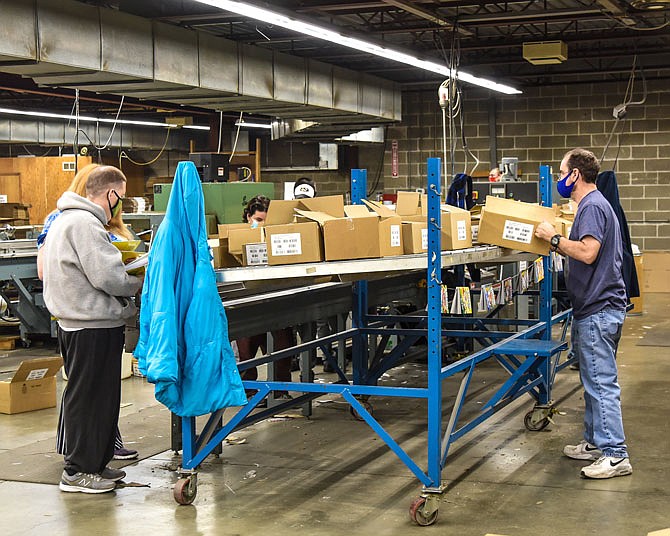 Employees at Jefferson City's Capitol Projects go about their daily tasks to complete jobs for local vendors. The sheltered workshop employs dozens of workers with special needs, some of whom currently earn minimum wage. 