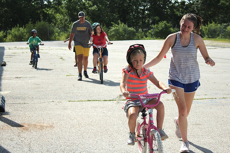 <p>Olivia Garrett/For the News Tribune</p><p>Kambree Vandloecht, 9, learned how to ride a bike during weekly bike practice sessions in 2020. Behind her, Harsha Sunder and Anna Peuster practice their own skills with the help of volunteers.</p>