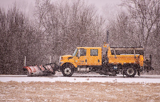 A MoDOT truck plows along U.S. 50 near Jefferson City as Mid-Missouri is hit with winter weather Saturday.  