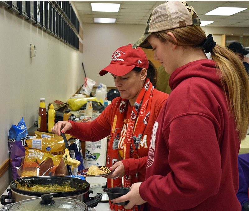 Gerry Tritz/News TribuneJulie Morff, left, and Natasha Jewell help themselves to snacks during Sunday's Super Bowl party at the Jefferson City Jaycees Fairgrounds.