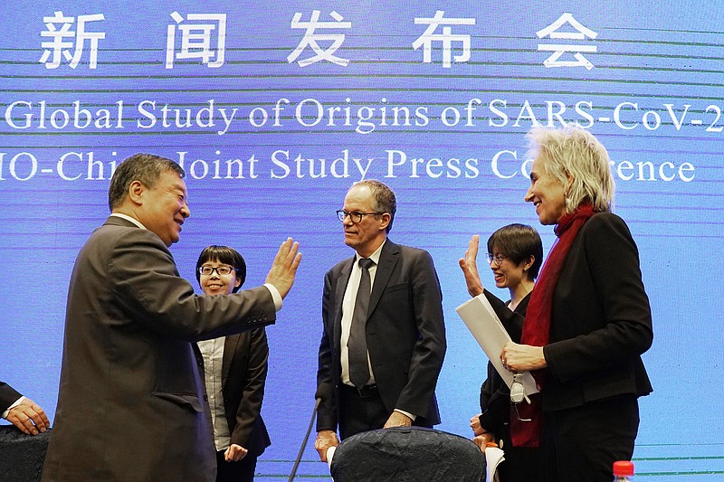 Marion Koopmans, right, and Peter Ben Embarek, center, of the World Health Organization team say farewell to their Chinese counterpart Liang Wannian, left, after a WHO-China Joint Study Press Conference held at the end of the WHO mission in Wuhan, China, Tuesday, Feb. 9, 2021. (AP Photo/Ng Han Guan)