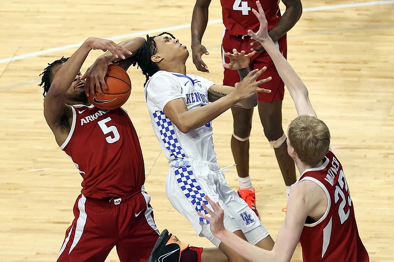 Kentucky's B.J. Boston, middle, has the ball taken from him by Arkansas' Moses Moody (5) near Connor Vanover during the second half of an NCAA college basketball game in Lexington, Ky., Tuesday, Feb. 9, 2021. (AP Photo/James Crisp)