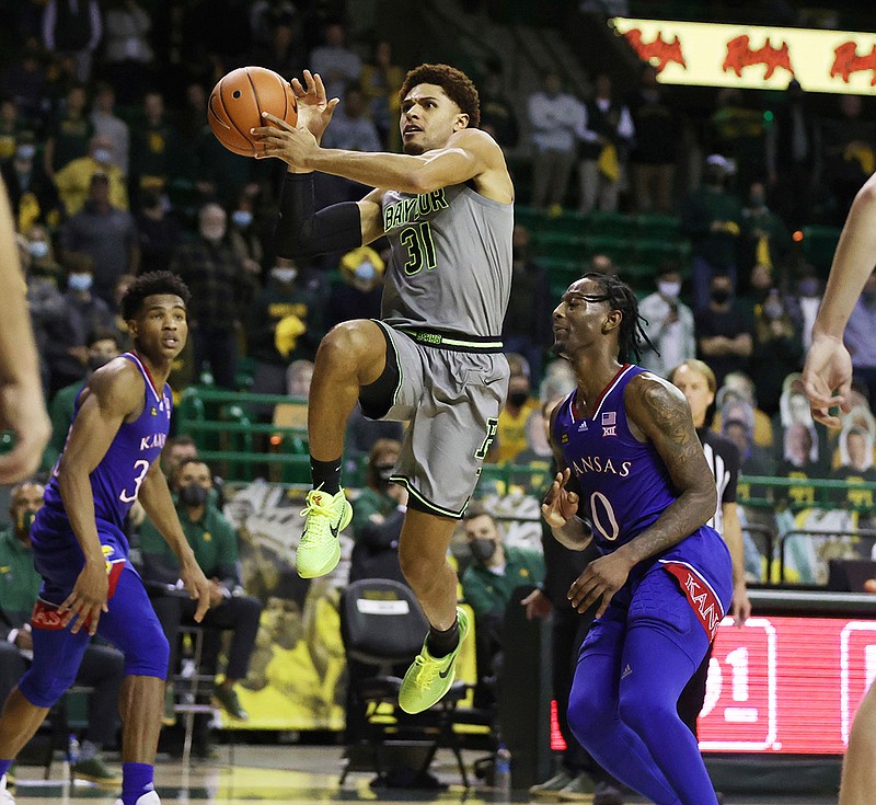 Baylor guard MaCio Teague, front left, scores past Kansas guard Marcus Garrett in the second half of an NCAA college basketball game, Monday, Jan. 18, 2021, in Waco, Texas. Teague and Davion Mitchell, two of the league's best shooters, were part of a Big 12-record 23-game winning streak last season in their debuts as Baylor starters. Those former transfers had also gone through a redshirt season together. (Rod Aydelotte/Waco Tribune-Herald via AP, File)