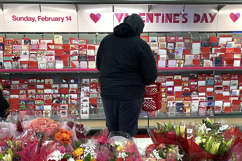 A shopper at a Chicago area store looks over Valentine's Day cards Saturday, Feb. 13, 2021. (AP Photo/Charles Rex Arbogast)