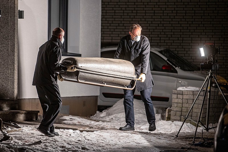 Undertakers carry a coffin out of a house in Radevormwald, Germany, Saturday, Feb. 13, 2021. Emergency services found five bodies after a fire at a house in western Germany and said Saturday they believe that a man fatally stabbed his wife, daughters and mother-in-law before killing himself. (Christoph Reichwein/dpa via AP)