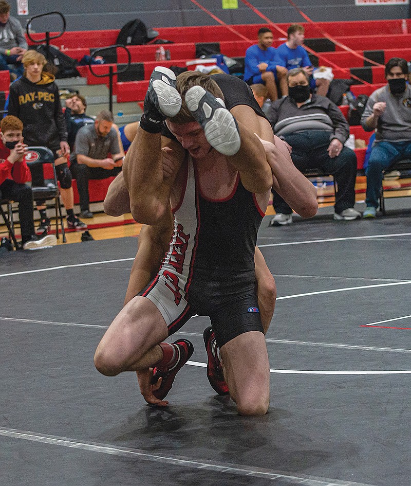 Hunter Walling of Jefferson City picks up Eli Van Trump of Raymore-Peculiar during their 132-pound title match Saturday in the Class 4 District 6 Tournament at Fleming Fieldhouse.
