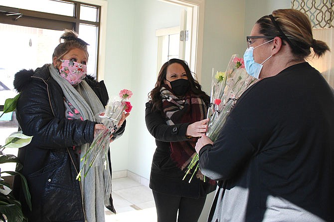 Justis Smith, of the Callaway Chamber of Commerce, and Andrea Bedrosian, of Callaway Community Hospital, delivered flowers for caregivers to hand out at local longterm care facilities.