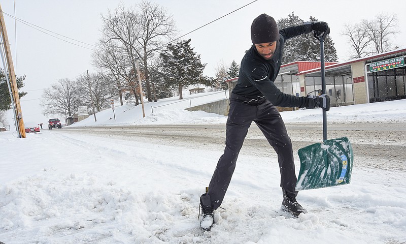 Alonzo Allen uses a plastic snow shovel to clear a path for mail delivery at his home on Jefferson Street in Jefferson City on Wednesday, Feb. 17, 2021.