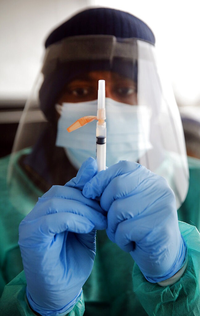 Volunteer pharmacist Glenn Wilson prepares to administer a COVID-19 vaccination at Fair Park in Dallas, Wednesday, Feb. 10, 2021.