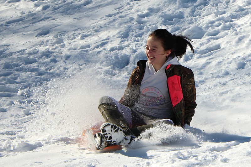 Riley Durlin takes a turn down a well-worn sledding hill Thursday at Veterans Park. 