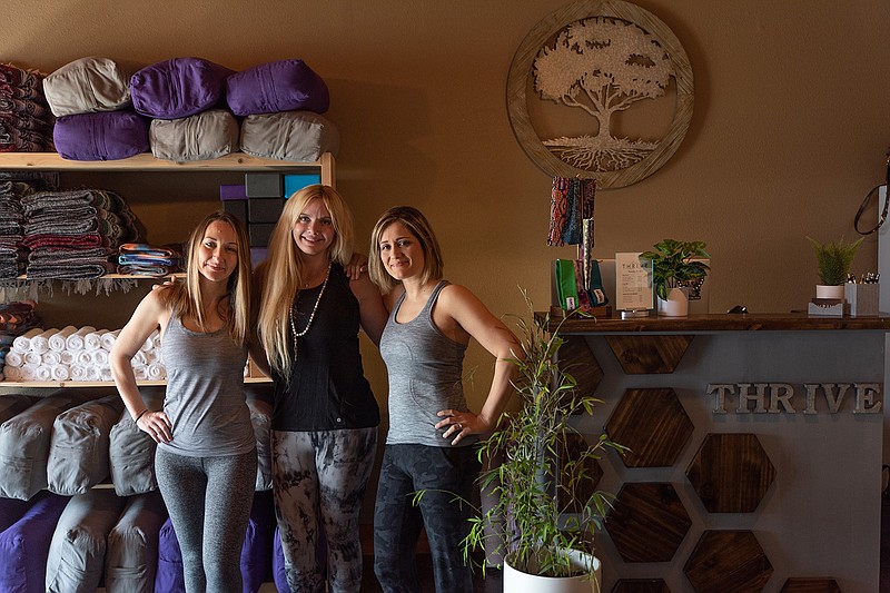 Brittany Carder, Amber Samuelson and Venus Lillis, co-owners of Thrive Yoga, pose for a photo in the yoga studio's lobby.

