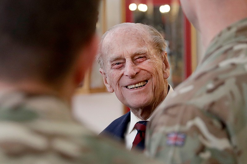 In this file photo dated Thursday, March 30, 2017, Britain's Prince Philip, in his capacity of Colonel, Grenadier Guards, talks to Sergeants from 1st Battalion Grenadier Guards as he walks in their Mess at Lille Barracks in Aldershot, England.  The 99-year-old husband of Queen Elizabeth II, Prince Philip was admitted to King Edward VII Hospital on Tuesday evening as "a precautionary measure" and is expected to remain there for a few days of "observation and rest." (AP Photo/Matt Dunham, FILE)