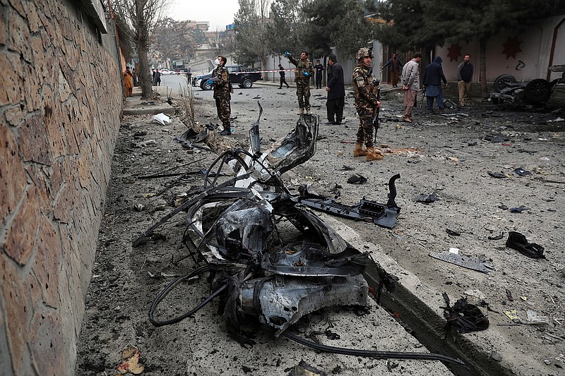 Security personnel inspect the site of a bomb attack in Kabul, Afghanistan, Saturday, Feb. 20, 2021. Three separate explosions in the capital Kabul on Saturday killed and wounded numerous people an Afghan official said. (AP Photo/Rahmat Gul)